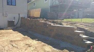 Long retaining wall installation in progress