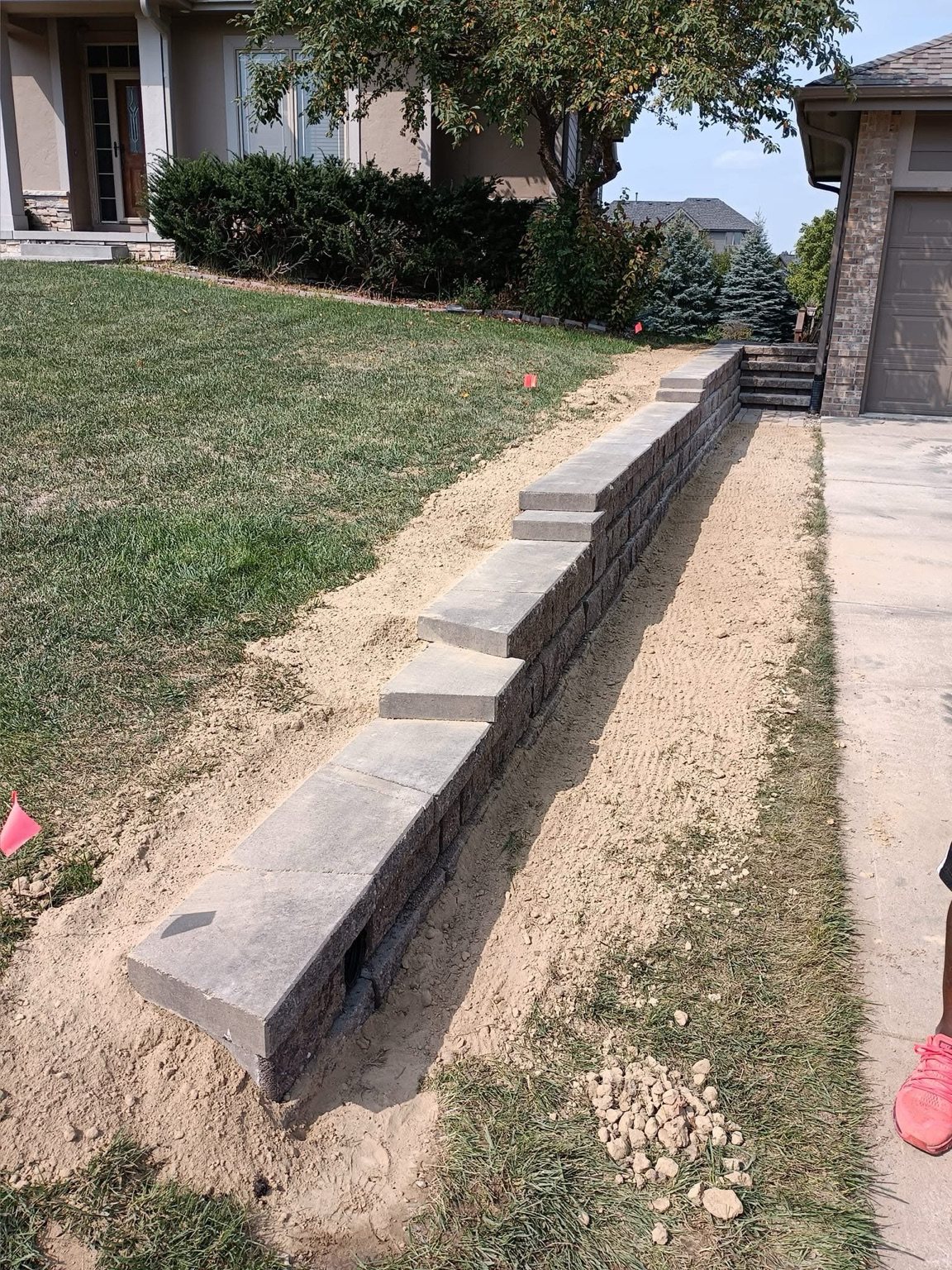 Long residential retaining wall beside driveway